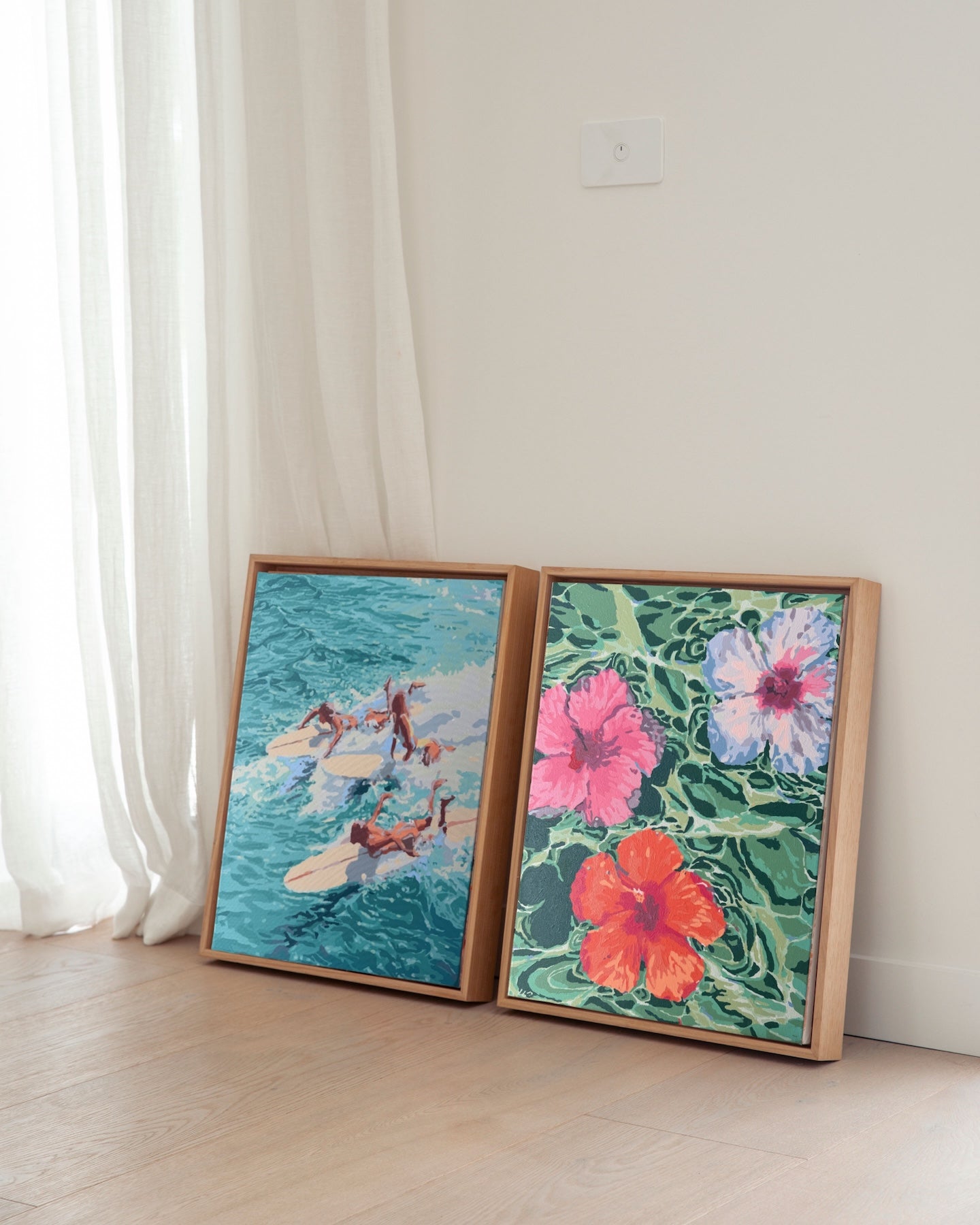 Paint Like Frida's Chaos and Hibiscus Dreams Big Framed Canvases displayed side by side on a timber floor, both in custom-made floating frames — vibrant paint by numbers artworks bringing a pop of colour to a sunlit corner.